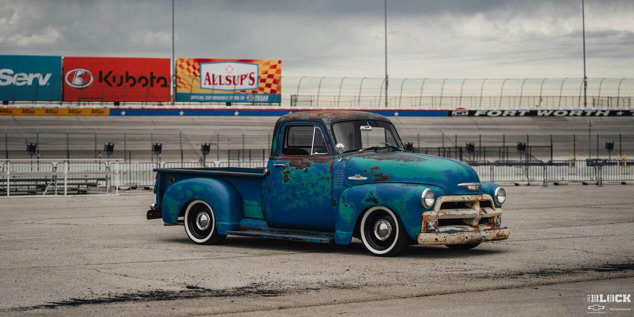 Left Three Quarters View of a Rusty 1955 Chevy Pickup Truck under a Cloudy Sky
