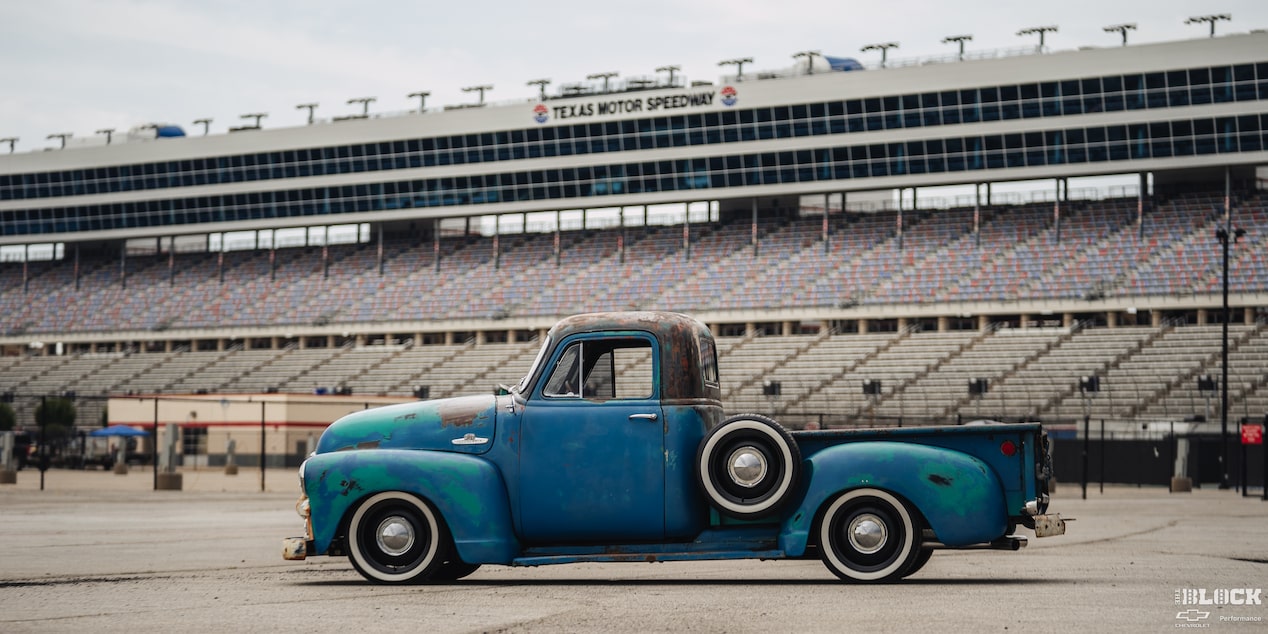 Side View of a Blue Rusty Chevy 1995 Chevy Pickup Truck in Front of a Stadium