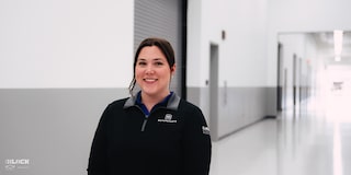 A Smiling Female GM Employee Wearing a GM Motorsports Shirt at the GM Charlotte Technical Center.