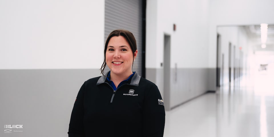 A Smiling Female GM Employee Wearing a GM Motorsports Shirt at the GM Charlotte Technical Center.