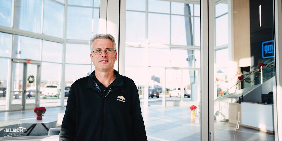 A GM Employee Stands and Smiles in the Lobby at the GM Charlotte Technical Center.