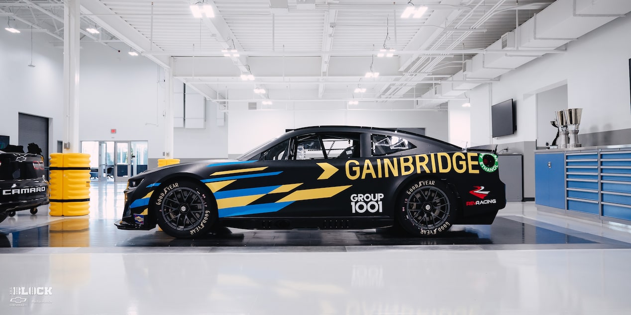 Side View of a Black Chevrolet Camaro Race Car with "Gainbridge" Written in Yellow Letters on the Side at the GM Charlotte Technical Center.