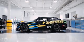 Side View of a Black Chevrolet Camaro Race Car with "Gainbridge" Written in Yellow Letters on the Side at the GM Charlotte Technical Center.