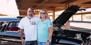 Louie y Laurie Fesmire de pie junto al Chevrolet Bel Air Nomad 1955 de Louie en un estacionamiento