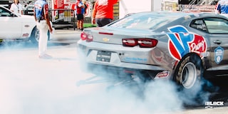Close Up of a Chevrolet Copo Camaro Performing a Burnout on a Track