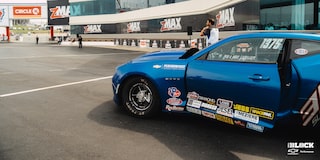 Side Close Up View of a Chevrolet Copo Camaro On The Track With The Driver's Door Open