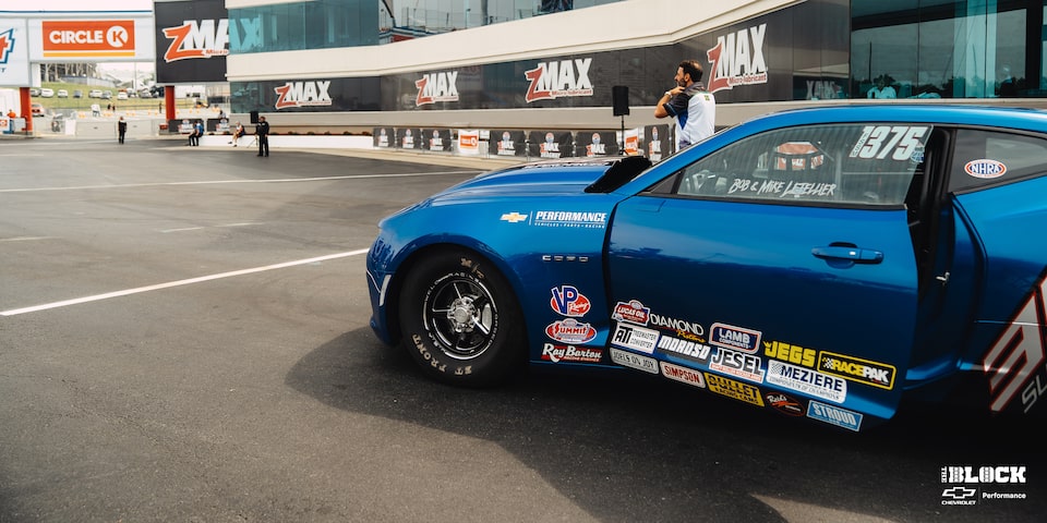 Side Close Up View of a Chevrolet Copo Camaro On The Track With The Driver's Door Open