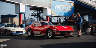 Two Vintage GM Sportscars Parked Near the Stands at Charlotte Motor Speedway