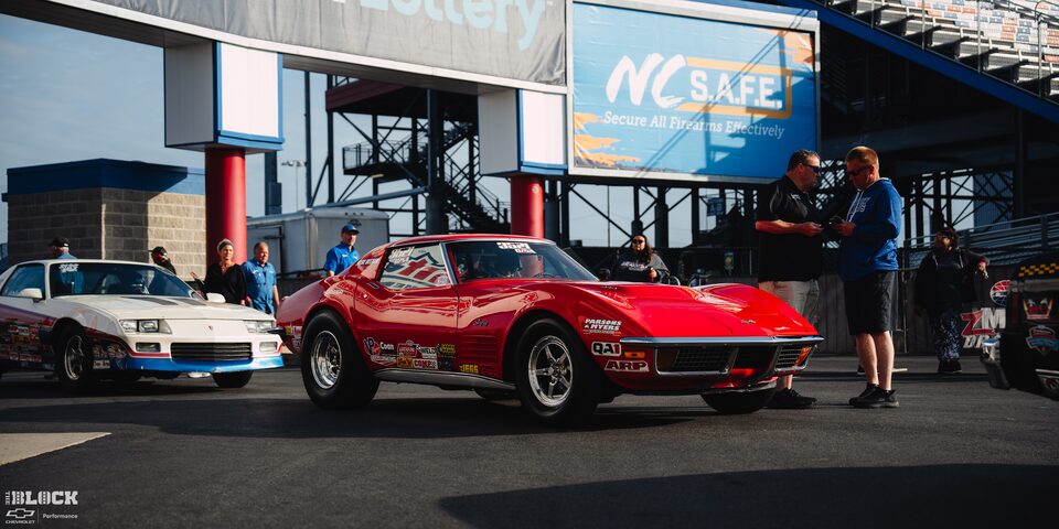 Two Vintage GM Sportscars Parked Near the Stands at Charlotte Motor Speedway