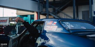 Rear Side Close-up View of a Blue Chevrolet Muscle Car With an Arm Reaching out the Open Door