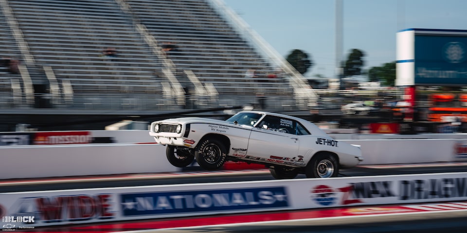 Side View of a White Chevrolet Muscle Car Speeding Down the Track at Charlotte Motor Speedway