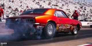 Rear Side View of a Classic Red Chevrolet Camaro Burning Rubber at the 2024 NHRA 4-Wide Nationals