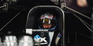 Close-up View of Racer John Force Strapped in His Race Car at Front View of a Black Chevrolet Camaro Funny Car Spitting Flames as It Speeds Down the Track at the 2024 Nhra 4-Wide Nationals