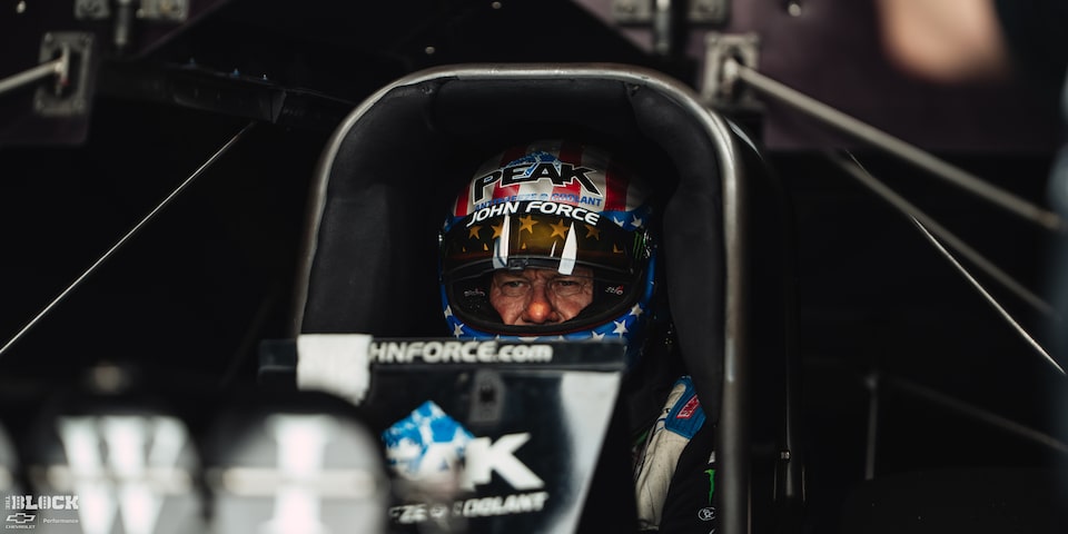 Close-up View of Racer John Force Strapped in His Race Car at Front View of a Black Chevrolet Camaro Funny Car Spitting Flames as It Speeds Down the Track at the 2024 Nhra 4-Wide Nationals