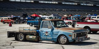 Side View of a Vintage Chevy Pickup Truck With "Grease Monkey" Written on the Passenger Door Under a Graphic at Texas Motor Speedway