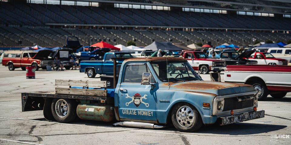 Side View of a Vintage Chevy Pickup Truck With "Grease Monkey" Written on the Passenger Door Under a Graphic at Texas Motor Speedway