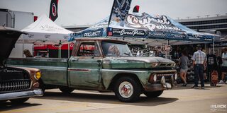 A Vintage Green Chevy Pickup Truck Parked Next to a "Sweet Patina" Tent at Texas Motor Speedway