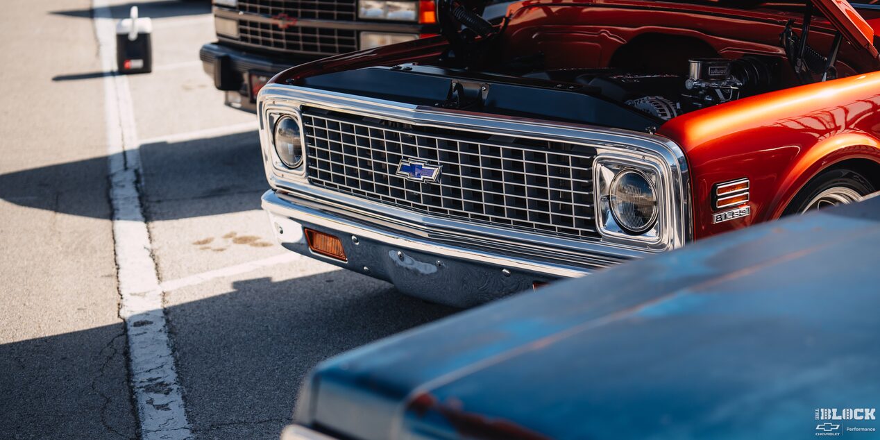 Close-up of an Orange Chevy Pickup Truck With an Open Hood Parked at Texas Motor Speedway