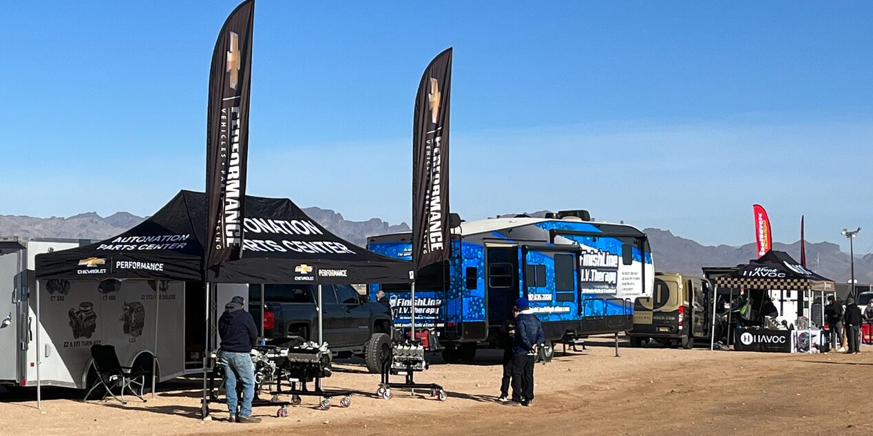 A View of Chevy Automation Parts Tent with a Trailer Vehicle Next to It in a Desert