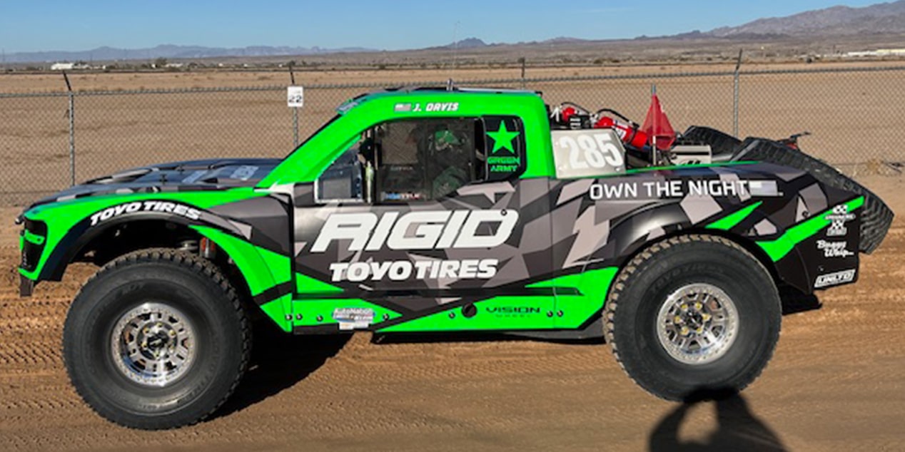 Side View of a Green and Black Colored Vehicle on a Desert