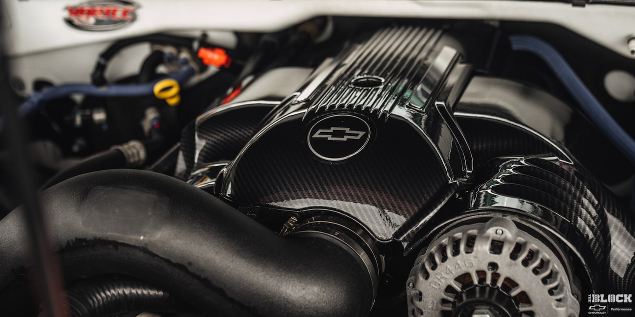 Close-up of Engine with a Chevy Emblem on It with Light Being Reflected from the Top