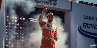Daniel Suárez Holding a Coke Bottle in with Smoke Coming from Behind Him