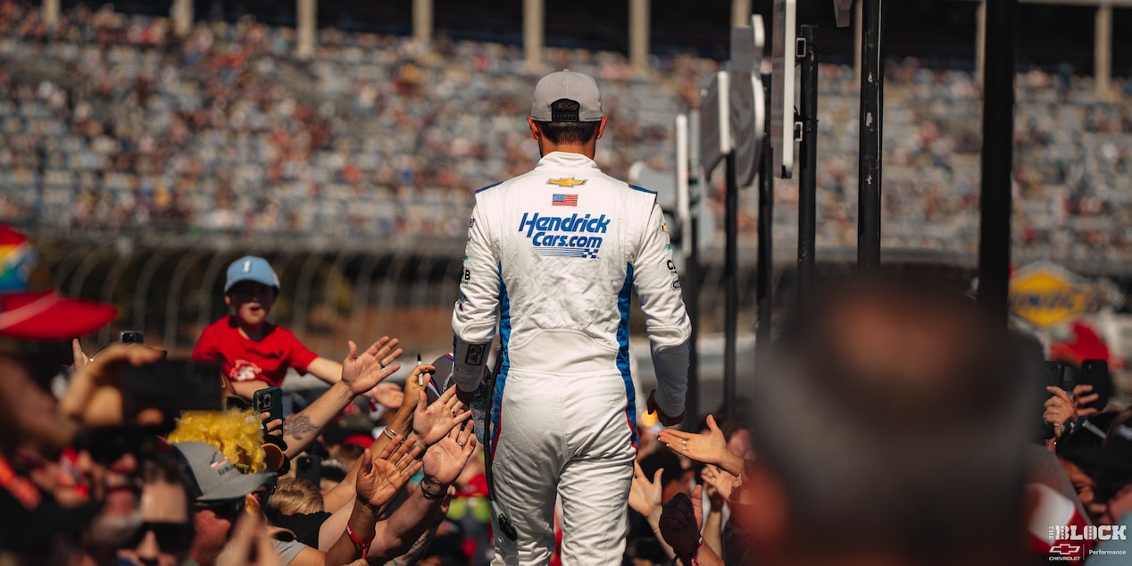 Rear View of a Racer Going Through the Crowed with Peoples Hands Reaching Out to Him