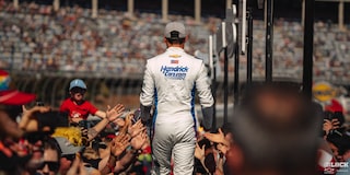 Rear View of a Racer Going Through the Crowed with Peoples Hands Reaching Out to Him