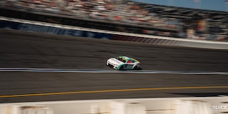 Three Quarters Far View of a Custom Chevy Racecar Driving Down the Track in a Crowded Stadium