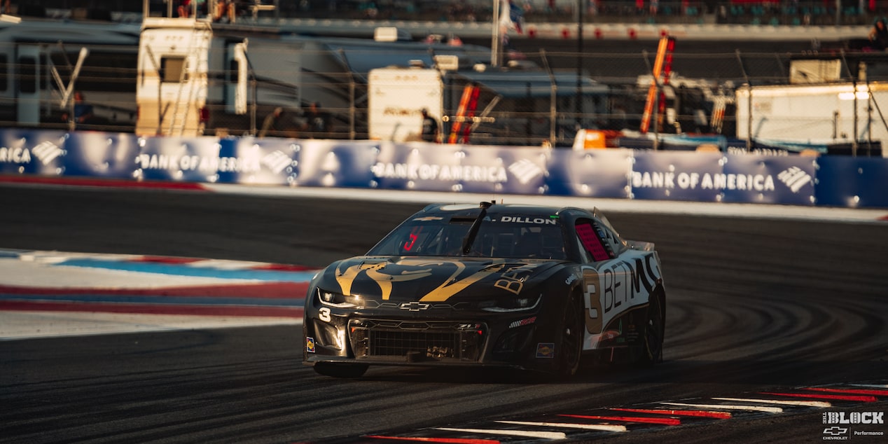 Three Quarters View of a Black Chevy Racecar Driving Down the Track in the Afternoon
