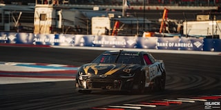 Three Quarters View of a Black Chevy Racecar Driving Down the Track in the Afternoon