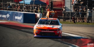 Front View of a Custom Orange and White Colored Chevy Racecar Drifting Down the Track