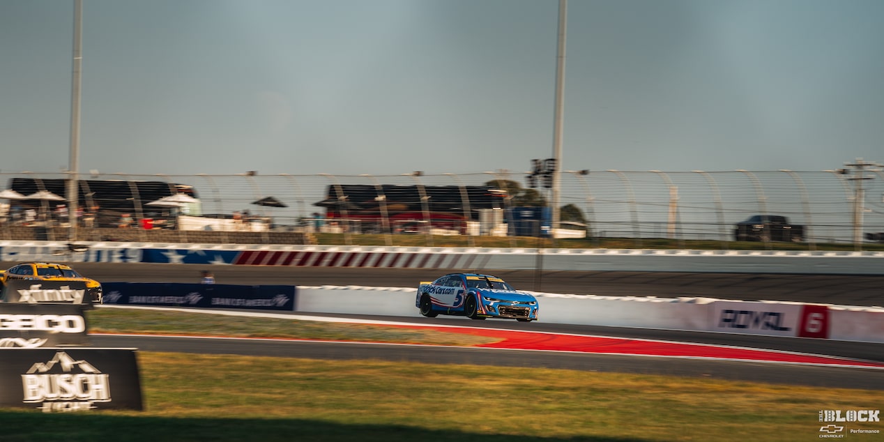 Faraway Shot of a Pair of Racecars Driving Down the Racetrack