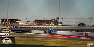 Faraway Shot of a Pair of Racecars Driving Down the Racetrack