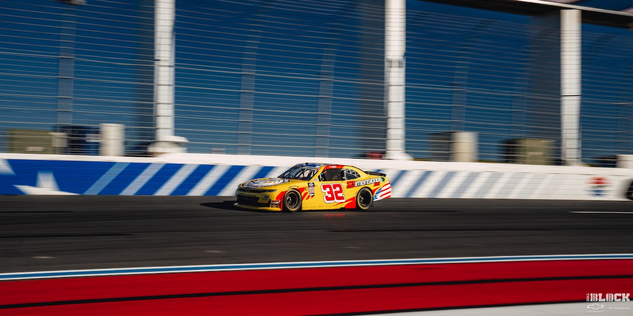 Three Quarters View of a Yellow Chevy Racecar on the Track on a Sunny Day