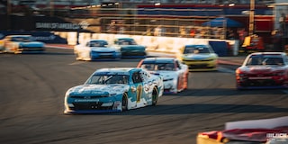 Three Quarters View of Many Chevy Racecars Racing on a Track on a Sunny Day