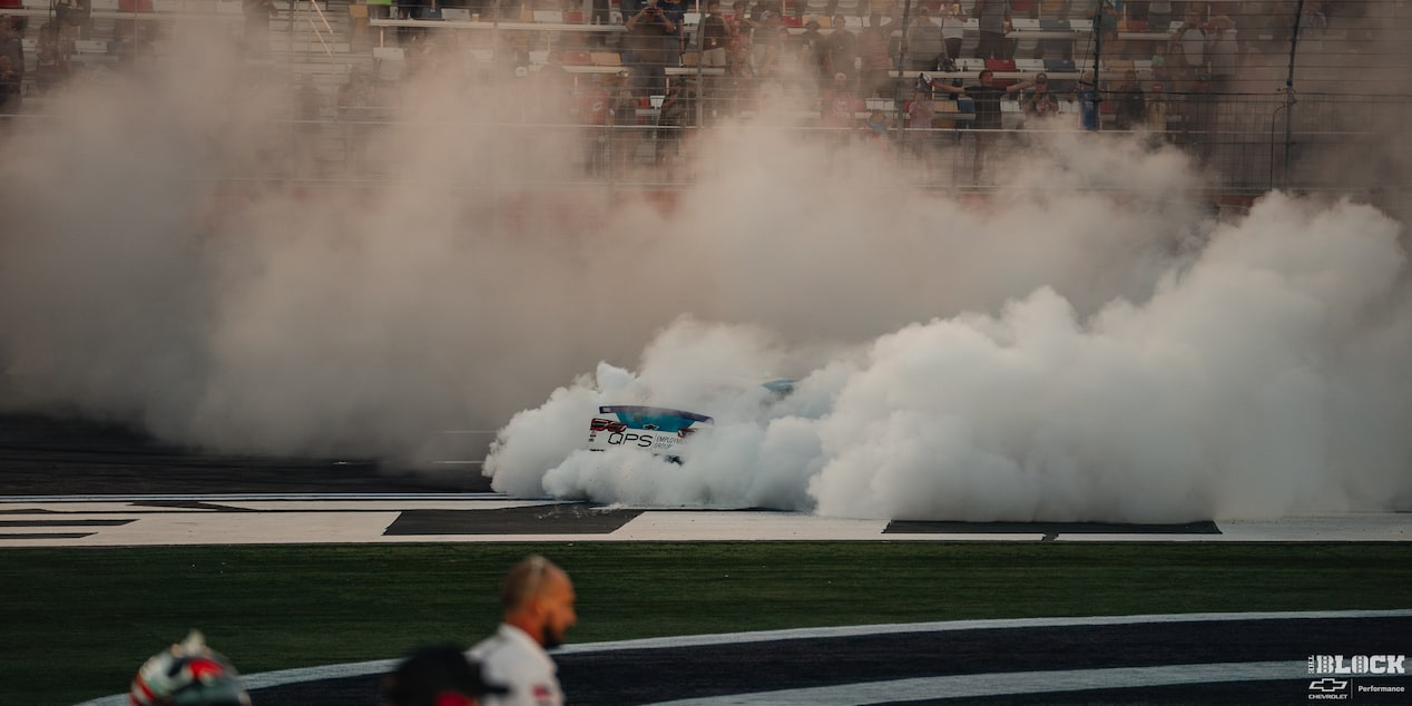 Smoke Covering the Whole Racetrack with the Barely Visible Rear of a Racecar in the Middle of It