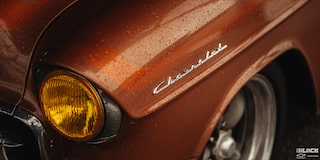 A Shot of the Written Chevrolet Logo on the Side of the Front Hood of an Orange 1955 Chevy Handyman Wagon