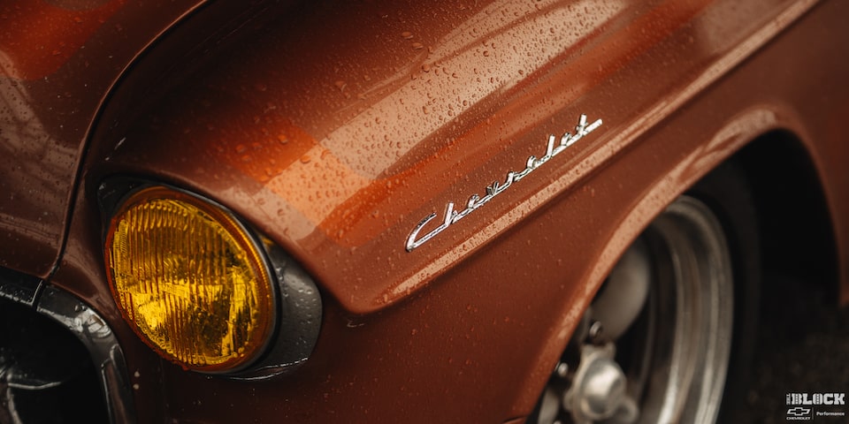 A Shot of the Written Chevrolet Logo on the Side of the Front Hood of an Orange 1955 Chevy Handyman Wagon