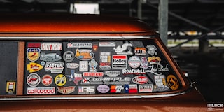Side View of Many Company Logos on the Left Rear Window of a 1955 Orange Chevy Handyman Wagon