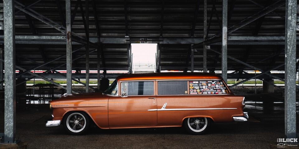 Side View of an Orange Chevy 1955 Handyman Wagon Wet from the Rain Parked under the Shade