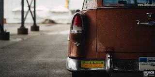 Rear View of a Wet Orange 1955 Chevy Handyman Wagon on the Left Side of the Frame