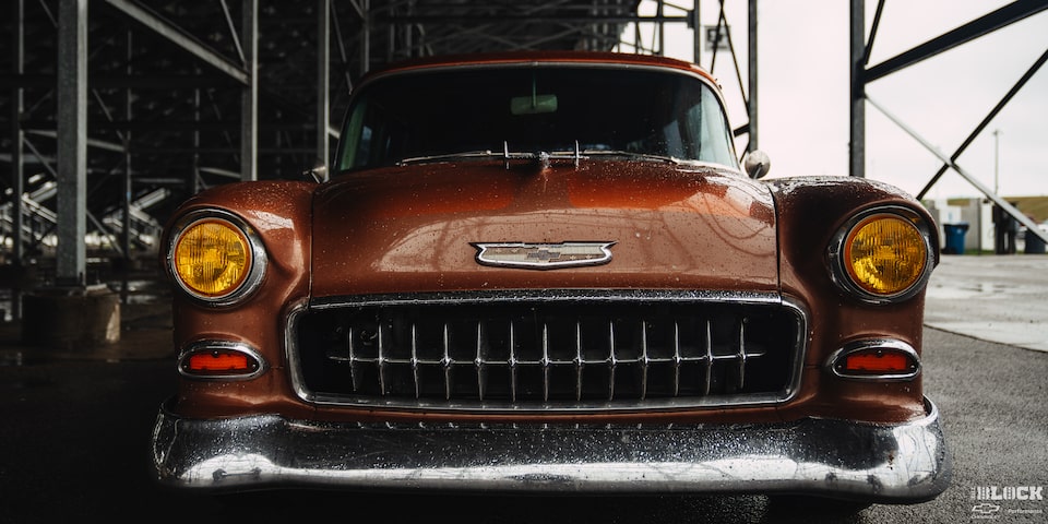 Low View of the Front of an Orange 1955 Chevy Handyman Wagon Wet from the Rain