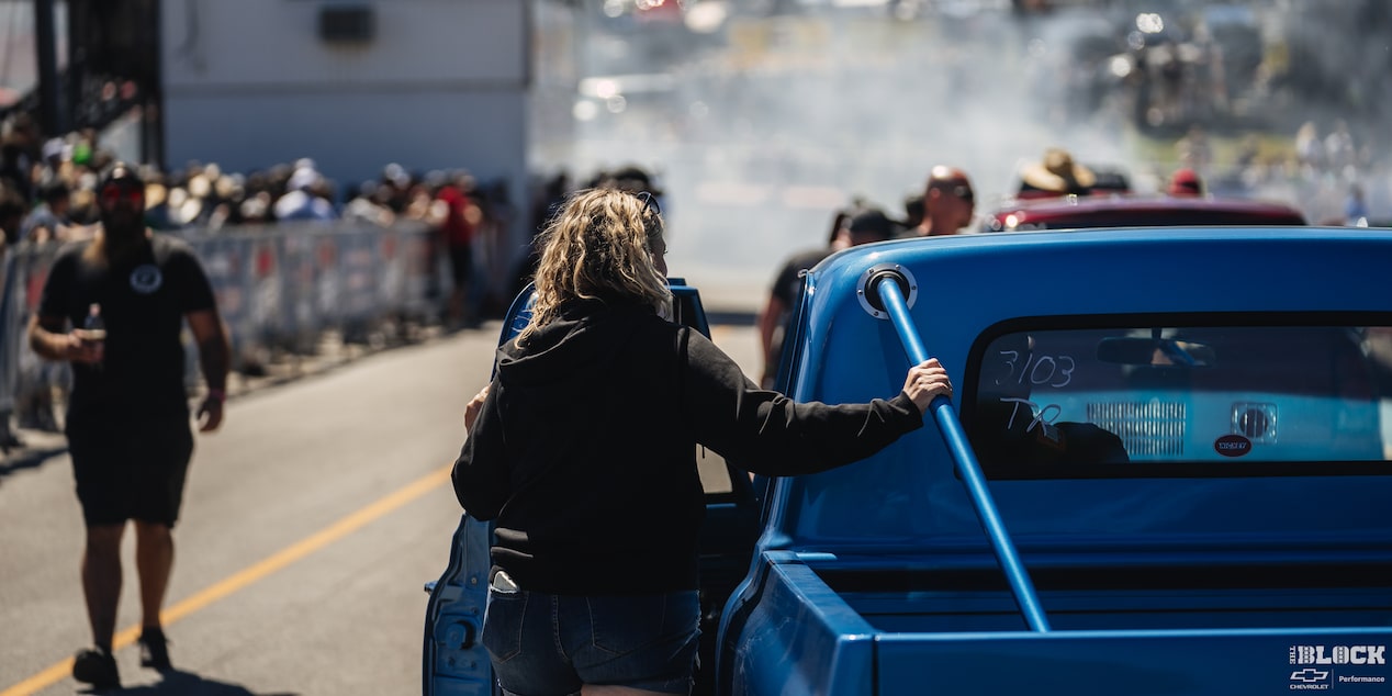 A Woman Places her Hand on a Chevy C10 Truck at a Racing Event