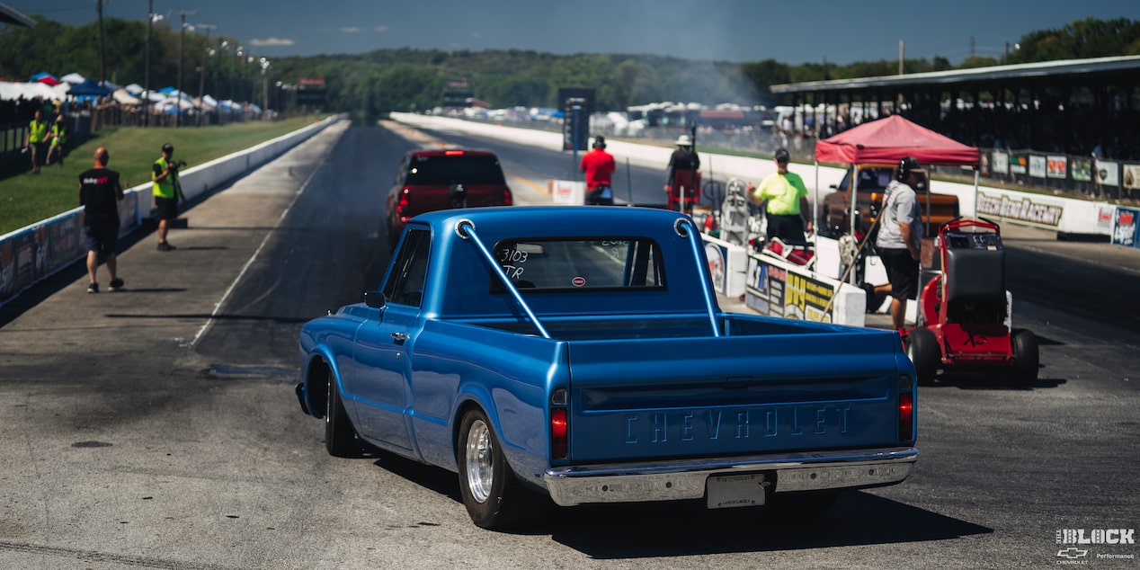 Three Quarters Rear View of a Blue Three Quarters Rear View of a Blue Chevy C10 Truck Going into the Racetrack on a Sunny Day with Smoke in the AirC10 Truck Going into the Racetrack on a Sunny Day with Smoke in the Air