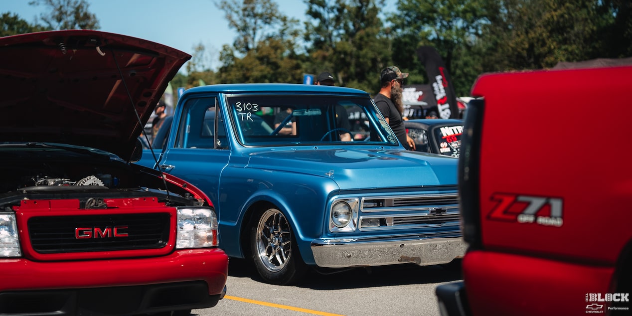 Rear View of a Blue Chevy C10 Truck Gearing Up for a Racing Event with Smoke Coming the Rear as It Burns Rubber