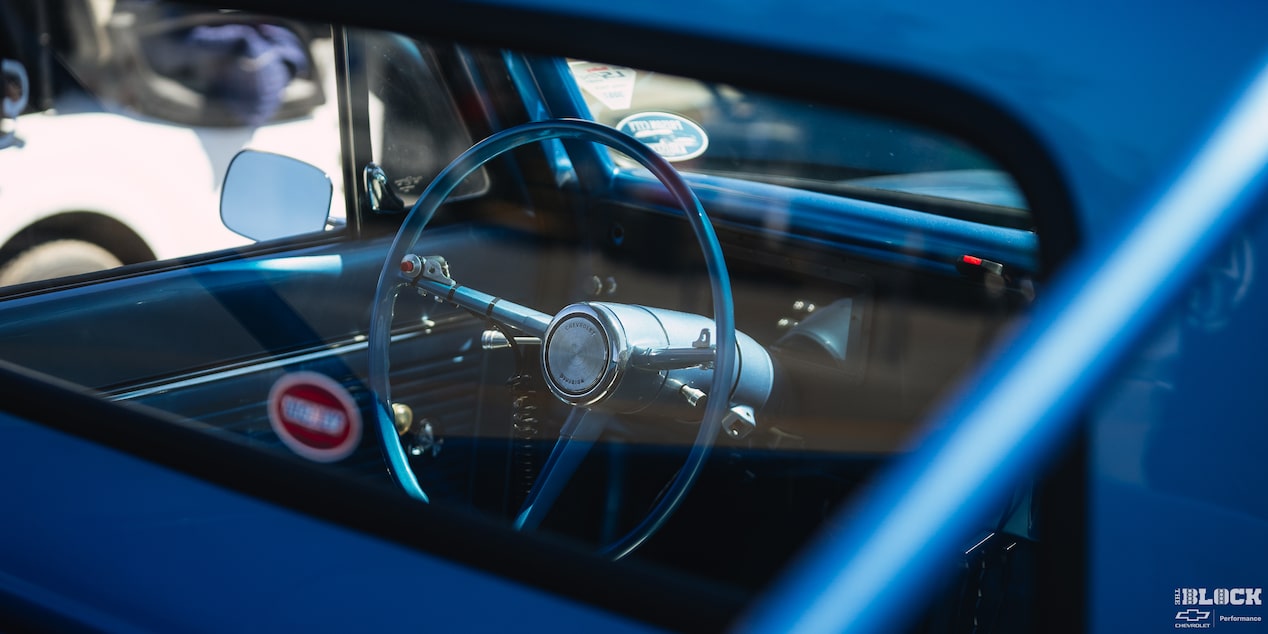 A Shot of the Steering Wheel of a Blue 1967 Chevy C10 Truck Seen from outside the Rear Window