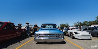 Eye Level View of a Blue 1967 Chevy C10 Truck with Other Vehicles Getting Ready to Race