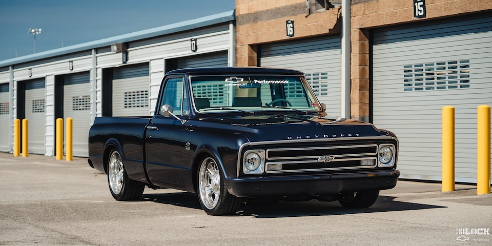A Black Chevy C10 Truck Parked Outside a Professional Garage