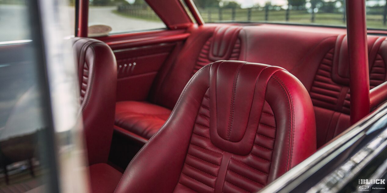 A View of the Red Interior of a 1964 Chevy Nova Seen from outside the Window